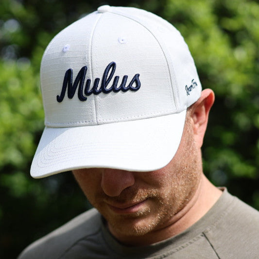 Man wearing a white cap with 'Mulus' logo outdoors