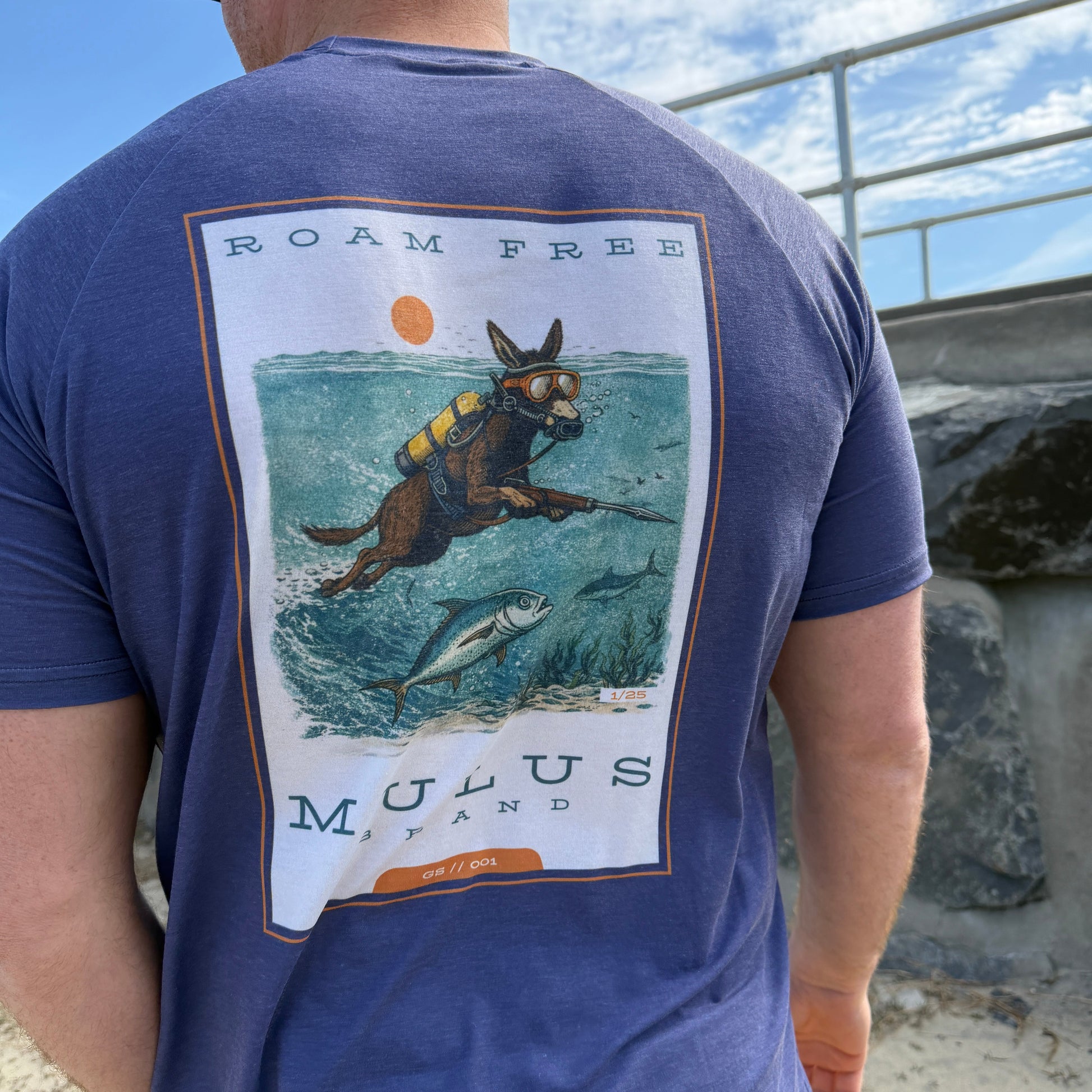 Person wearing a blue t-shirt with a graphic design of a donkey spear fishing 