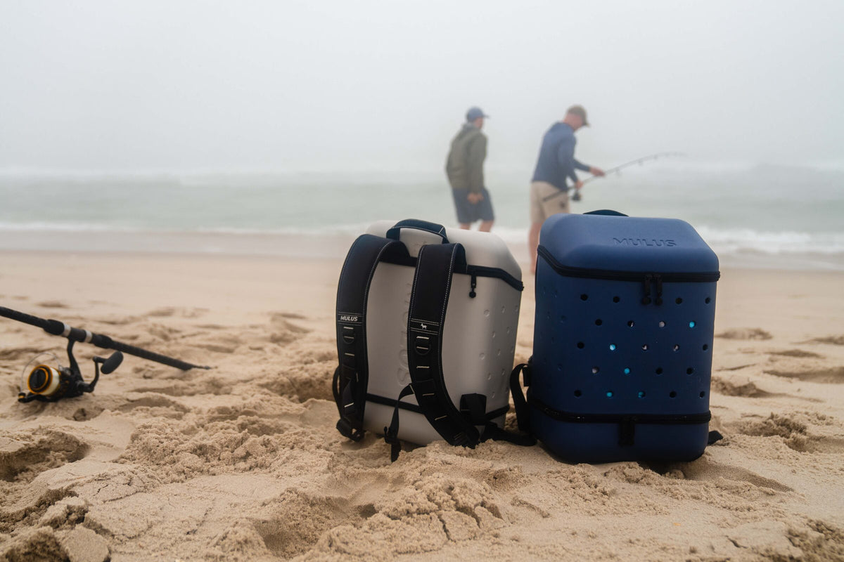 Ash Gray and Abyss Blue MULUS ROAMER backpacks on the beach